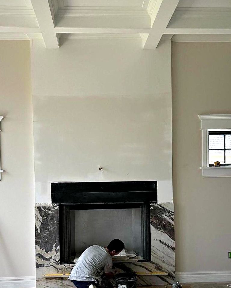 The same living room before: a plain black fireplace insert being prepared for slab