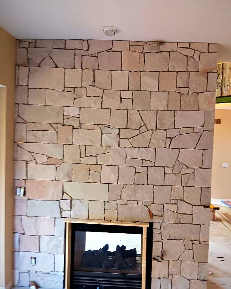 Natural stone ashlar pattern wall around a see-through gas fireplace